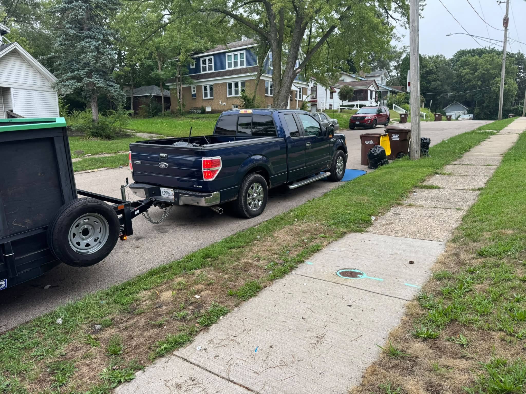 Our two-person crew in purple shirts carrying a dresser out of a Rockford garage